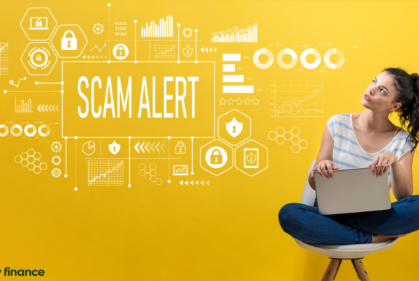 A woman sitting on a chair looking at an illustration with "scam alert" written in the middle